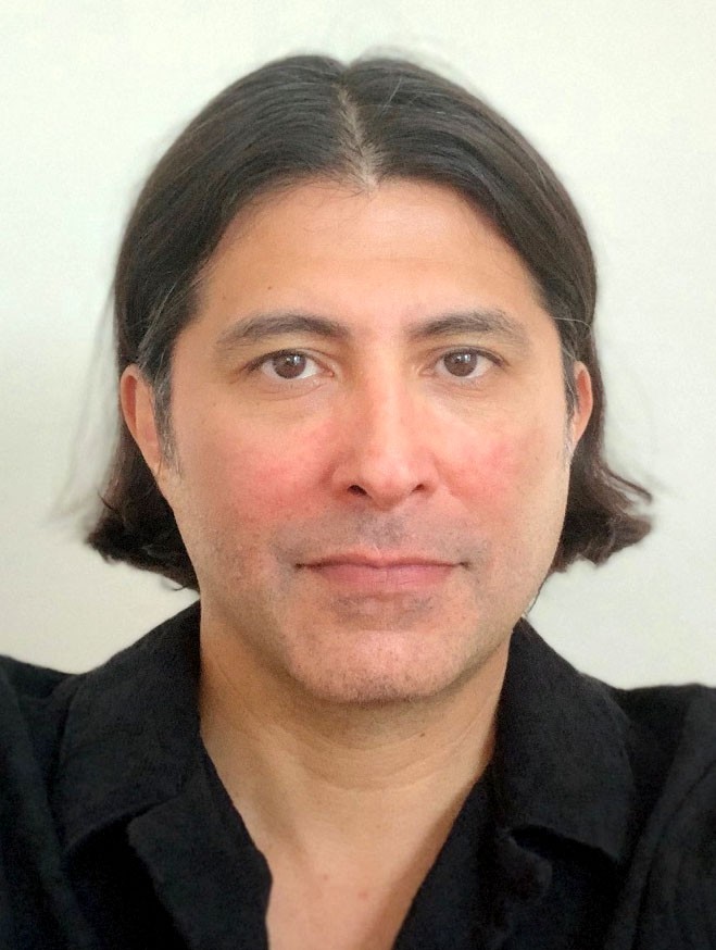 there is a man with long hair and a black shirt posing for a picture