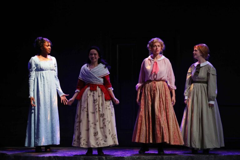 there are three women standing on a stage with one holding the other ' s hand